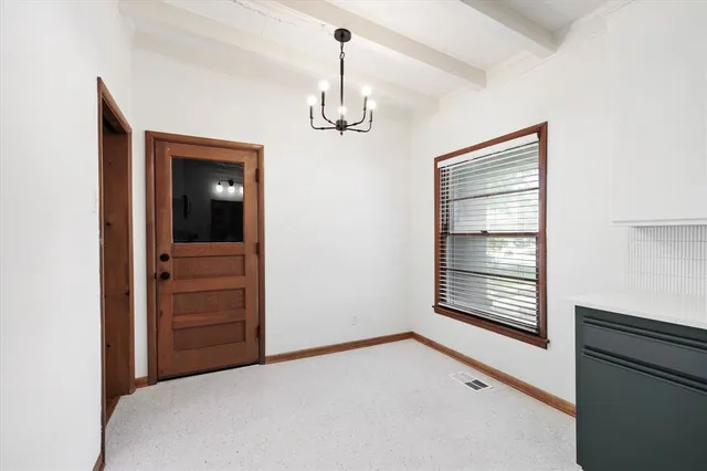 a view of empty room with cabinet and refrigerator
