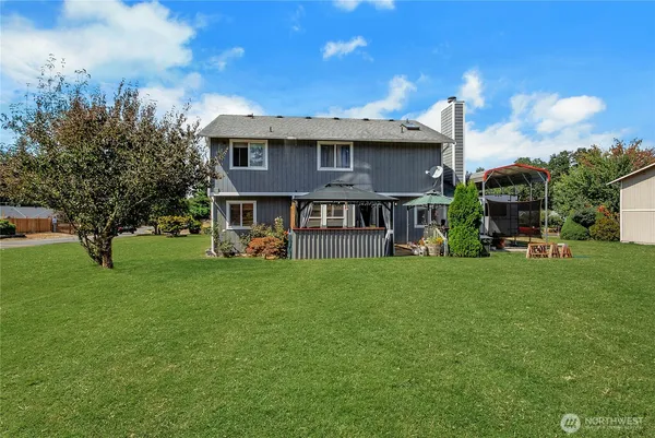 a view of an house with backyard and a tree