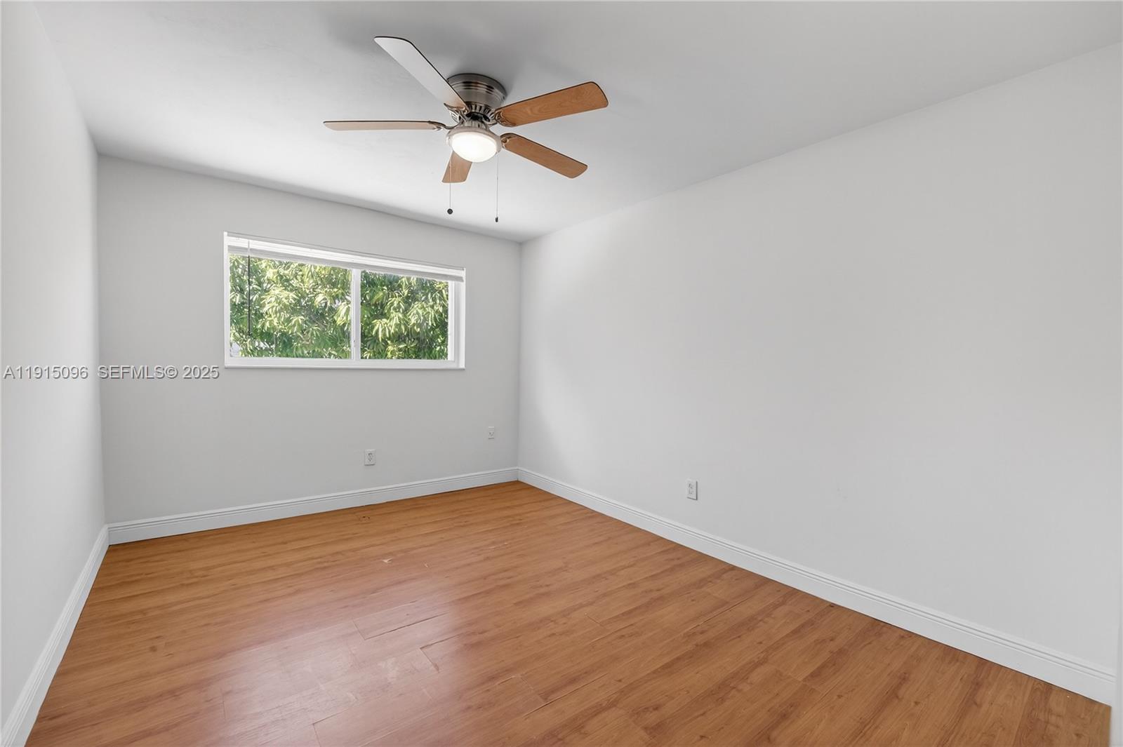 6822 West 2nd Lane Hialeah, FL 33014 - Photo 19 of 36 an empty room with wooden floor chandelier and windows