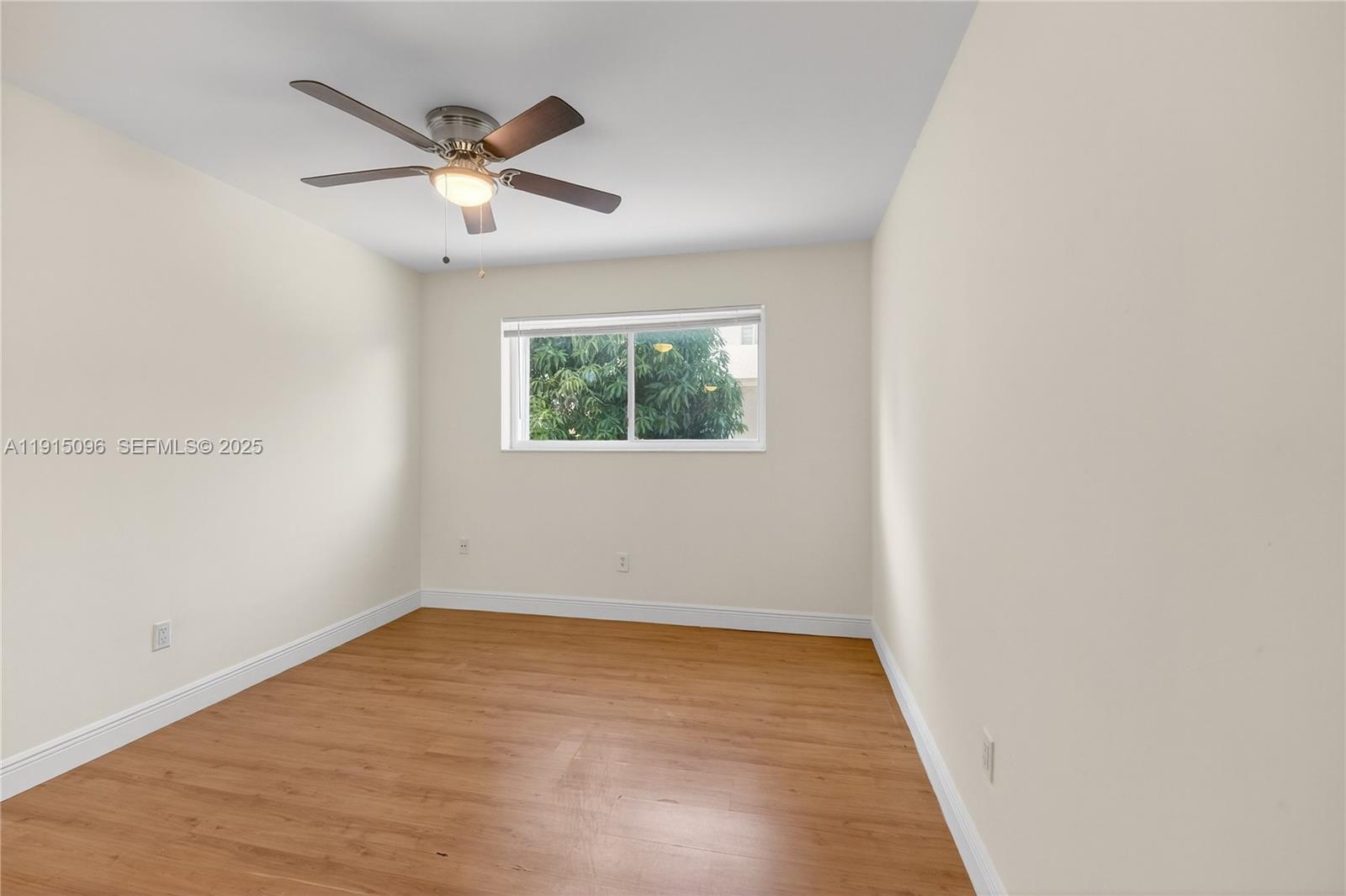 6822 West 2nd Lane Hialeah, FL 33014 - Photo 20 of 36 an empty room with wooden floor fan and windows