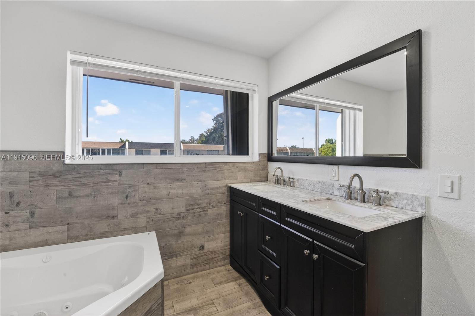 6822 West 2nd Lane Hialeah, FL 33014 - Photo 27 of 36 a bathroom with a double vanity sink and a large mirror