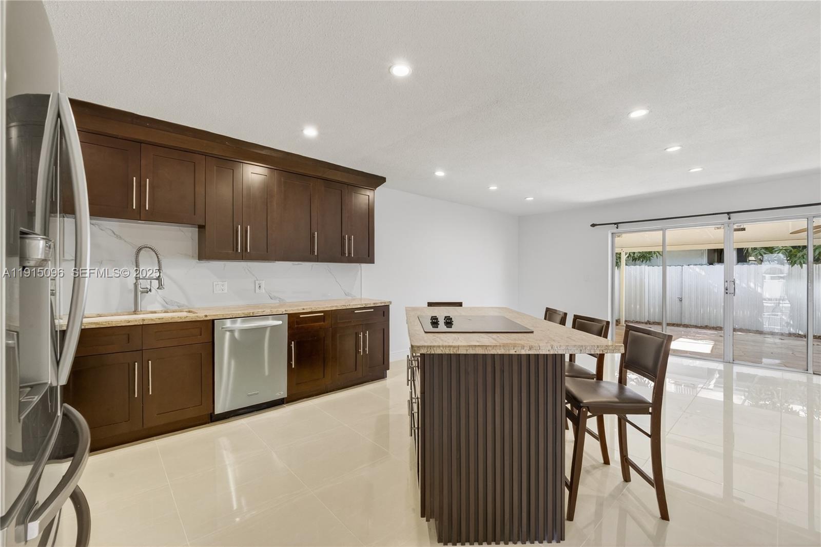 6822 West 2nd Lane Hialeah, FL 33014 - Photo 6 of 36 a kitchen with stainless steel appliances granite countertop a sink a stove a refrigerator a microwave with a dining table and chairs