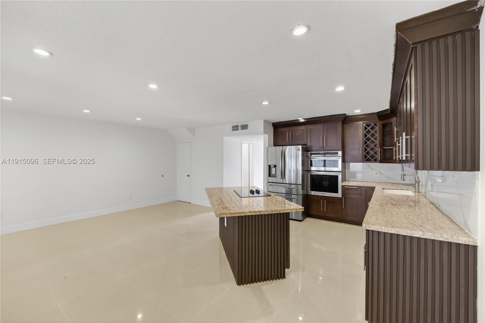 6822 West 2nd Lane Hialeah, FL 33014 - Photo 8 of 36 a kitchen with stainless steel appliances kitchen island granite countertop a refrigerator a stove and a sink with wooden cabinets