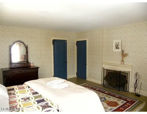1 Bray Road Heath, MA 01346 - Photo 13 of 23 a bedroom with a bed and a fireplace with a chair