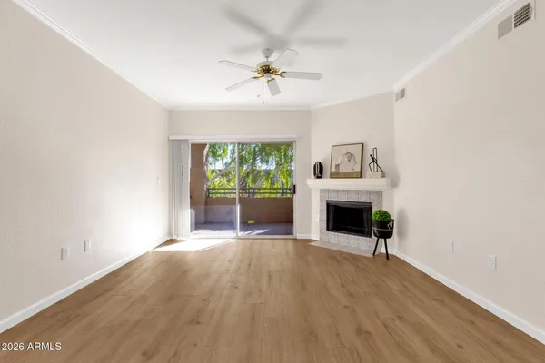 a view of an empty room with a fireplace and a window