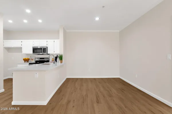 a view of a kitchen with wooden floor and electronic appliances
