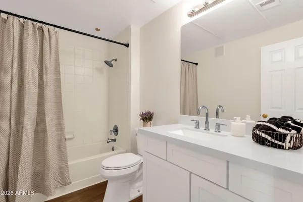 a bathroom with a sink a toilet a tub and shower