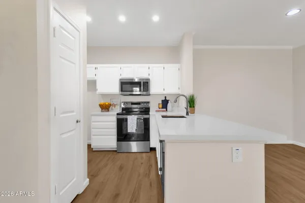 a kitchen with kitchen island a counter top space stainless steel appliances and cabinets