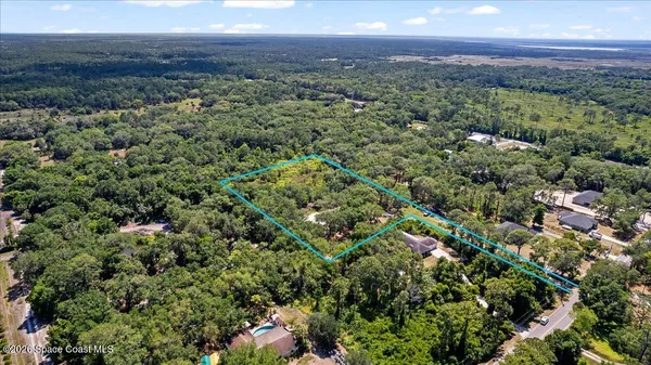 an aerial view of a houses with a yard