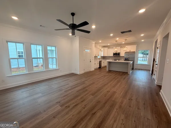 an open kitchen with kitchen island wooden floor and window