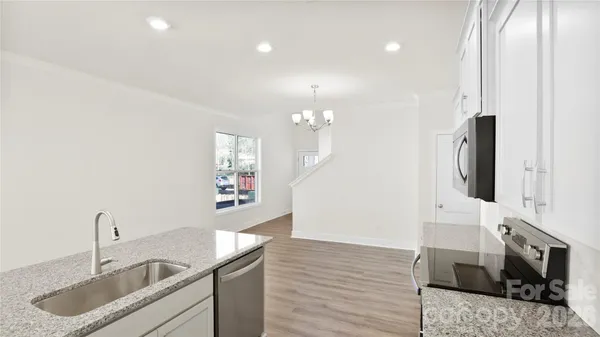 a kitchen with stainless steel appliances granite countertop a sink a stove and a refrigerator