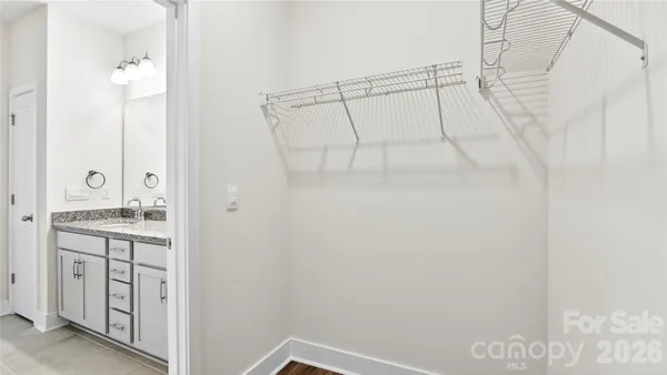 a bathroom with a granite countertop shower sink and white cabinets