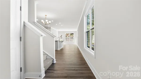 a view of a hallway with wooden floor and staircase