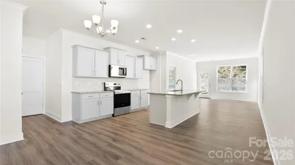 a large kitchen with kitchen island white cabinets and stainless steel appliances