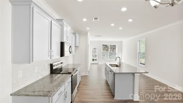 a large kitchen with stainless steel appliances granite countertop a large counter top and a stove