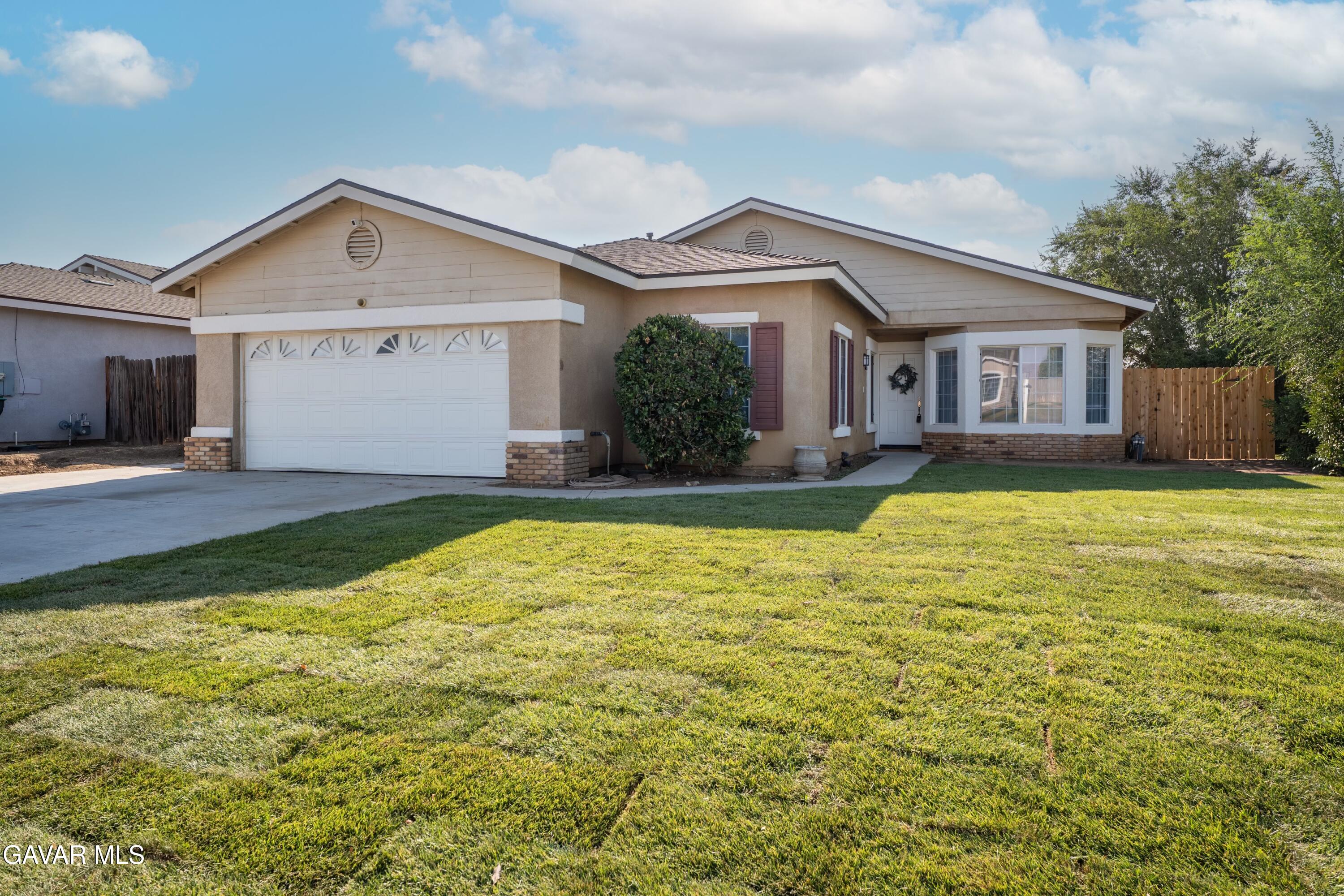 a front view of house with yard and garage