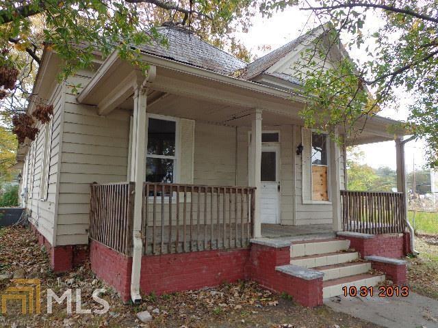 a view of a house with a small yard and wooden floor and fence