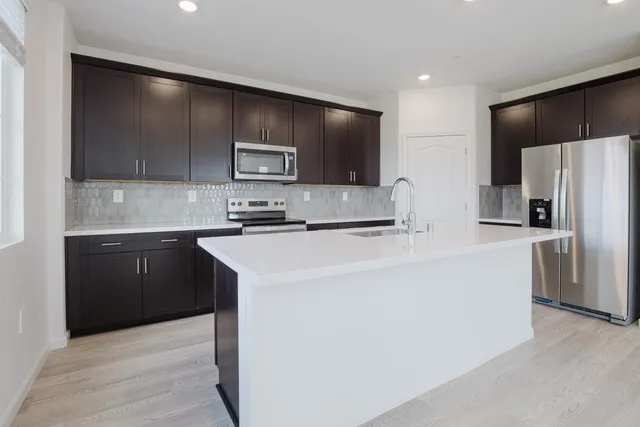 a kitchen with granite countertop a stove and a refrigerator
