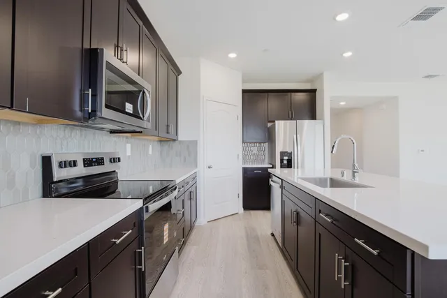 a kitchen with granite countertop a sink a stove and cabinets
