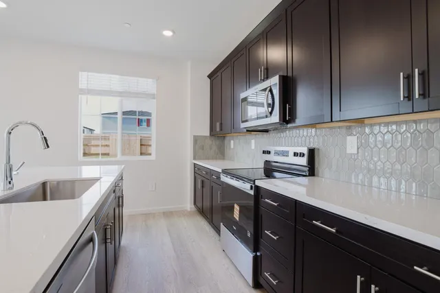 a kitchen with stainless steel appliances a refrigerator sink and microwave