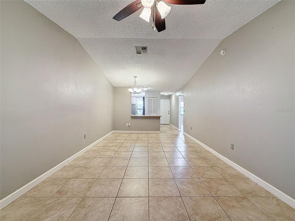 7116 Barclay Avenue, Unit B Spring Hill, FL 34609 - Photo 14 of 31 an empty room with a empty space and chandelier fan