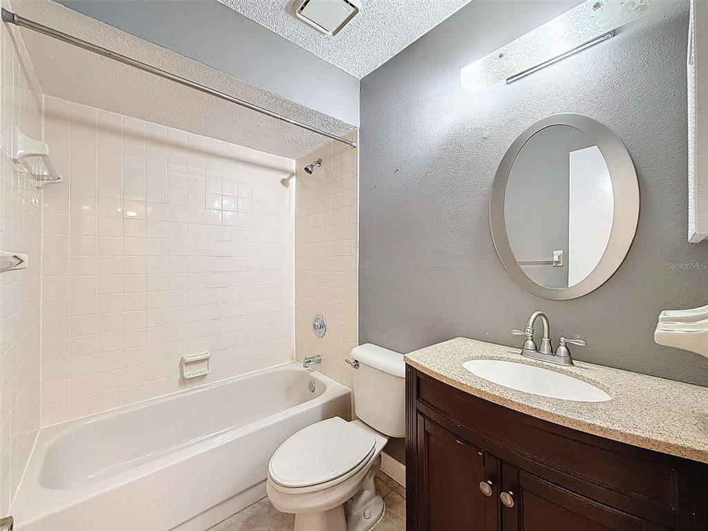 7116 Barclay Avenue, Unit B Spring Hill, FL 34609 - Photo 18 of 31 a bathroom with a granite countertop sink toilet a mirror and shower