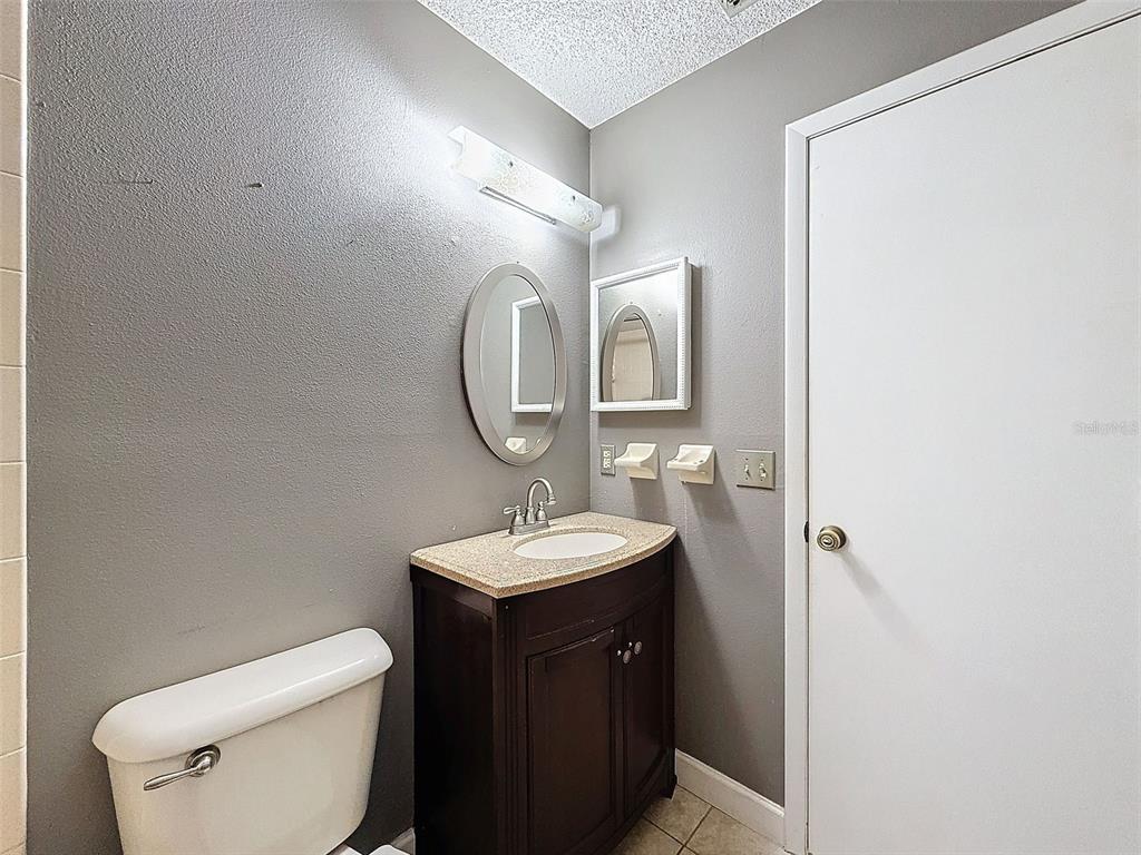 7116 Barclay Avenue, Unit B Spring Hill, FL 34609 - Photo 19 of 31 a bathroom with a toilet a sink and mirror