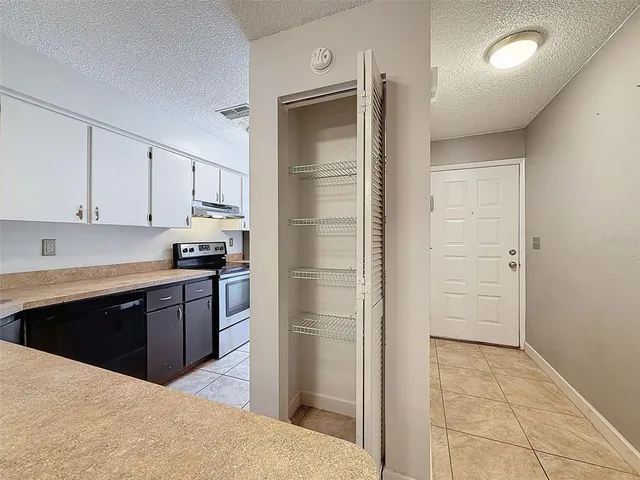 a kitchen with a refrigerator and white cabinets