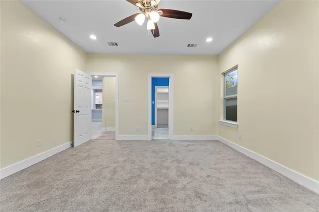 an empty room with fan and entrance