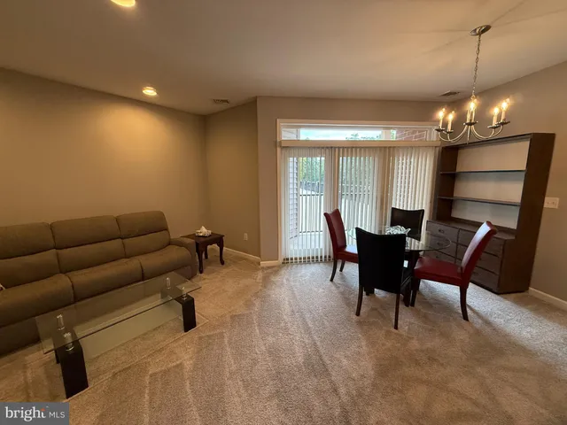 a living room with furniture a dining table and chairs with kitchen view