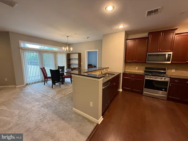 a kitchen with granite countertop wooden cabinets and stainless steel appliances