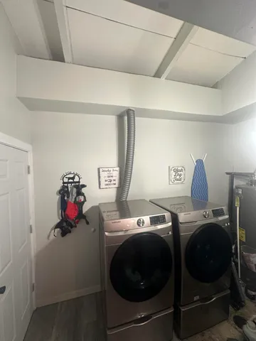 a utility room with dryer washer and shoe rack