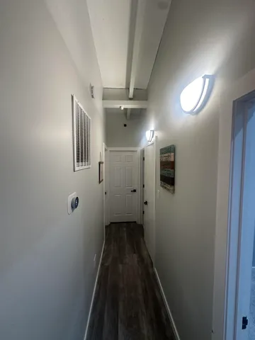 a view of a hallway with wooden floor