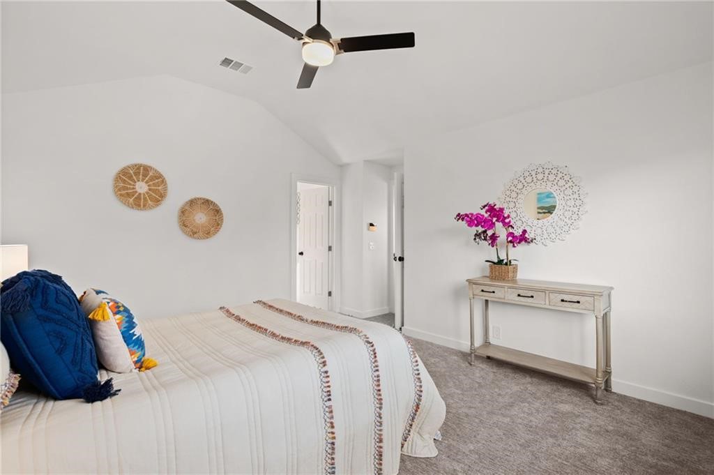 16724 Trevin Cove Manor, TX 78653 - Photo 18 of 32 a bedroom with a bed and a chandelier