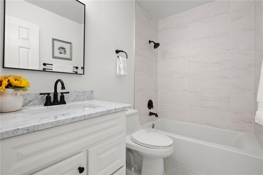 16724 Trevin Cove Manor, TX 78653 - Photo 24 of 32 a bathroom with a sink a toilet and a bathtub