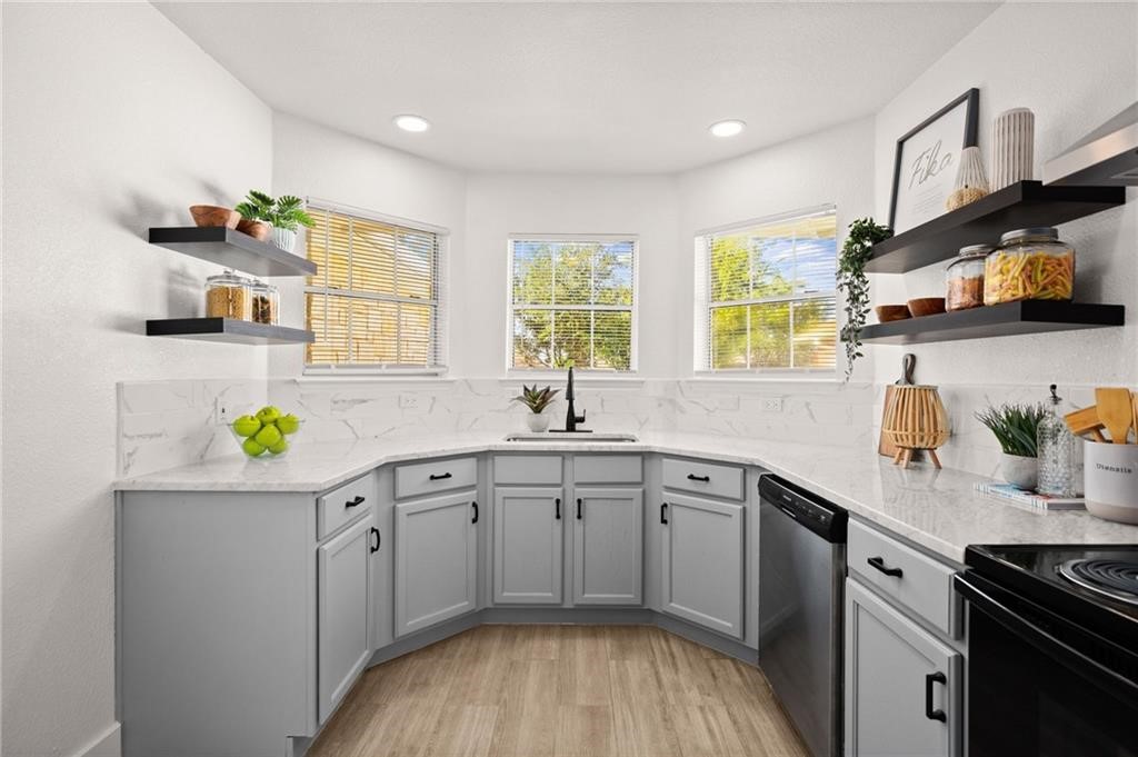 16724 Trevin Cove Manor, TX 78653 - Photo 8 of 32 a kitchen with a sink a window cabinets and appliances