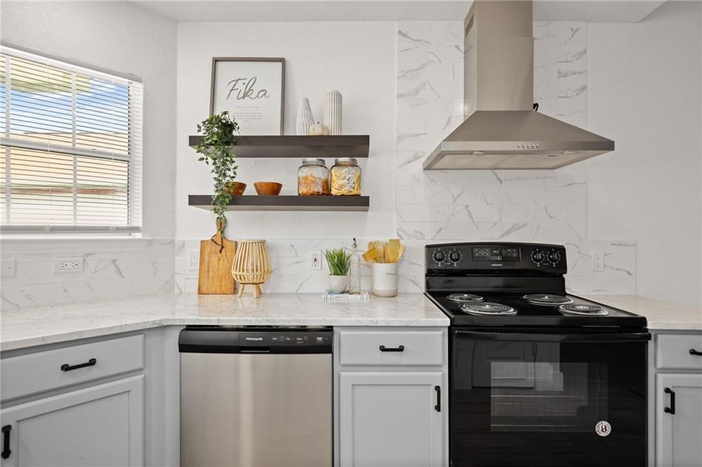 16724 Trevin Cove Manor, TX 78653 - Photo 10 of 32 a kitchen with stainless steel appliances granite countertop a sink a stove and a granite counter tops with white cabinets