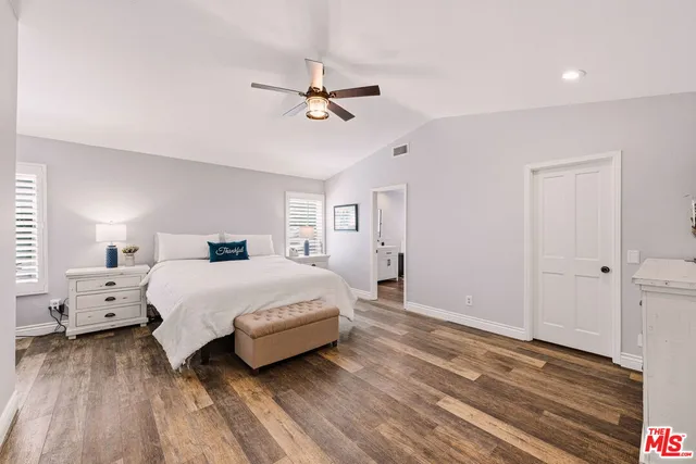 a spacious bedroom with a bed and a chandelier