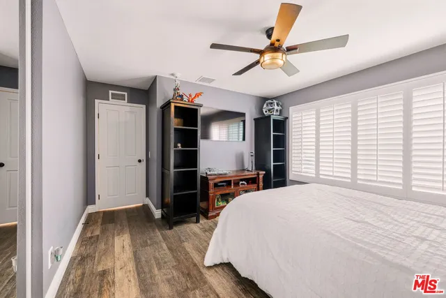 a bedroom with a bed and a ceiling fan