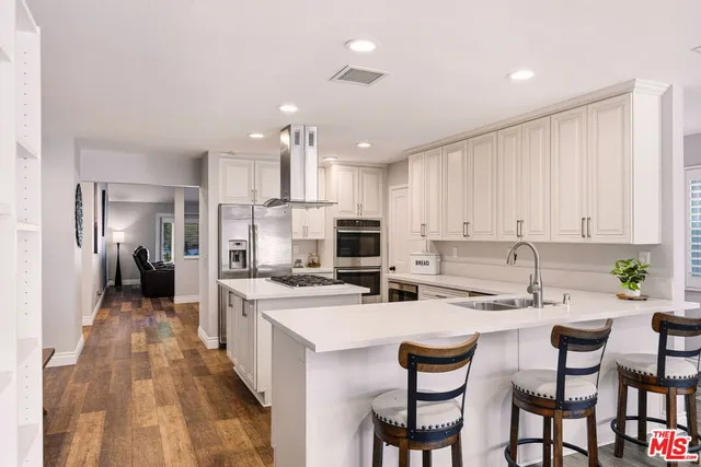 a kitchen with a dining table chairs refrigerator and cabinets