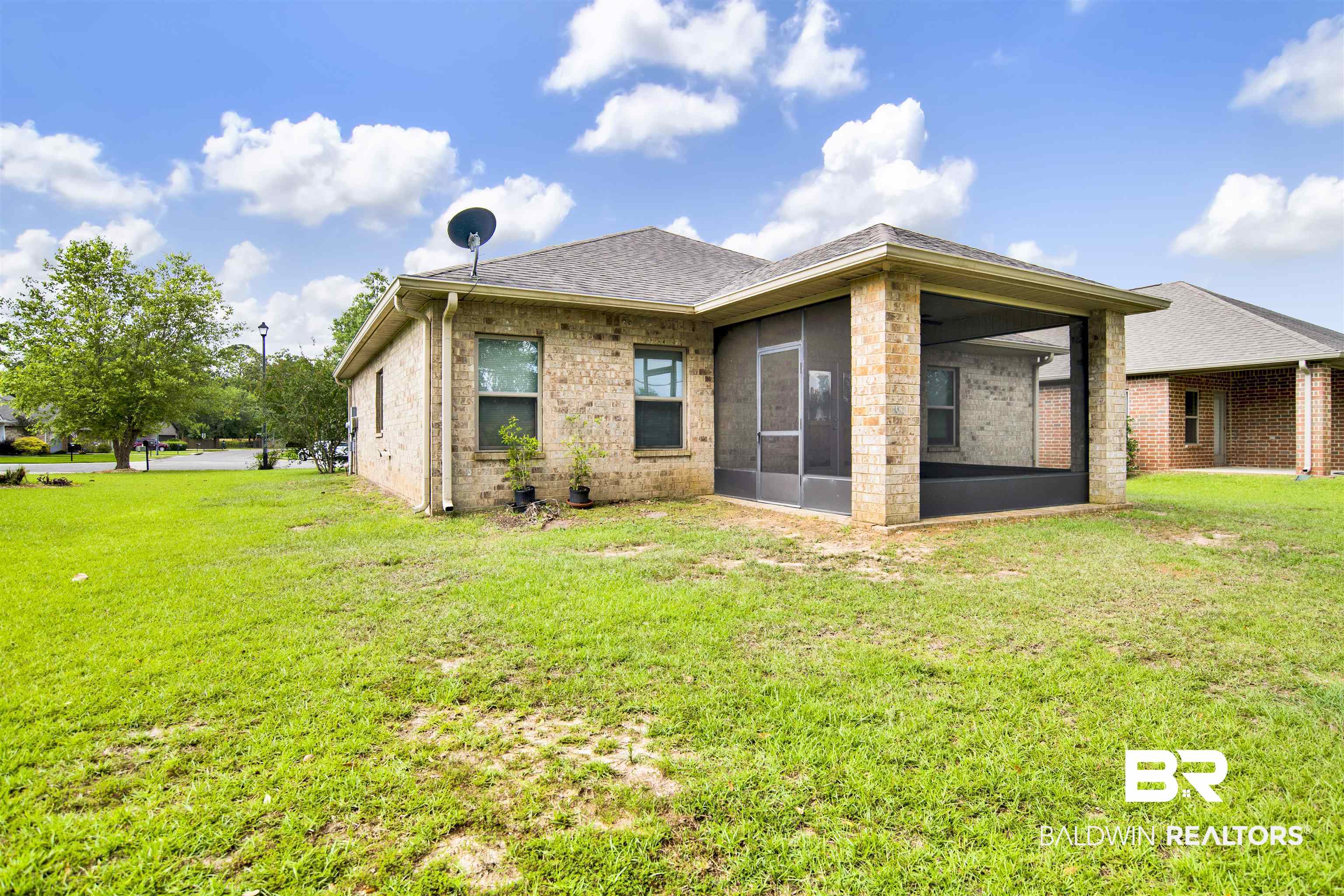 1468 Surrey Loop Foley, AL 36535 - Photo 26 of 28 Back of property with a sunroom, a lawn, brick siding, and roof with shingles