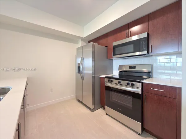 a kitchen with stainless steel appliances granite countertop a refrigerator stove and microwave