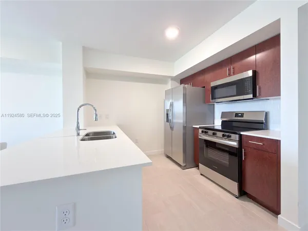 a kitchen with stainless steel appliances a sink stove and refrigerator