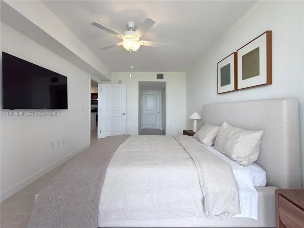 a bedroom with a bed and a flat screen tv