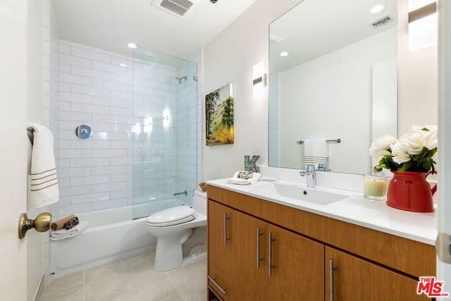 a bathroom with a double vanity sink toilet and shower