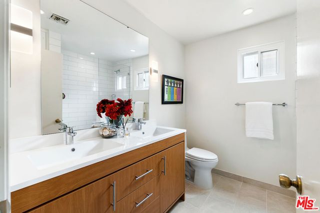 a bathroom with a double vanity sink mirror and toilet