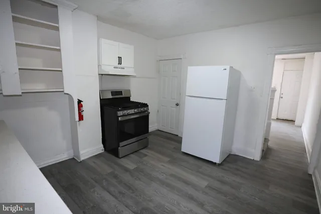a kitchen with a refrigerator and a stove top oven