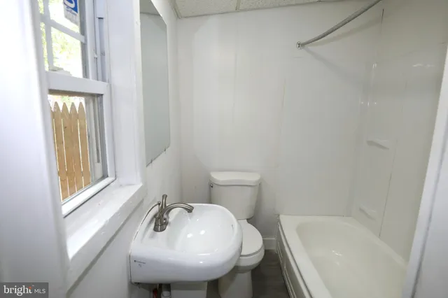 a bathroom with a sink a toilet and tub