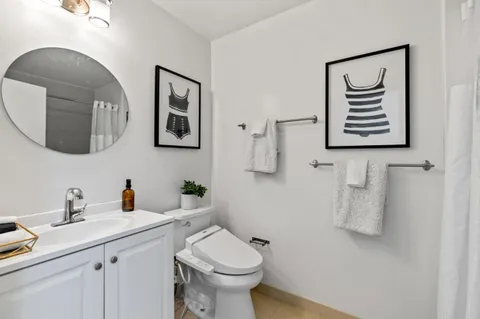 a bathroom with a toilet a sink and mirror