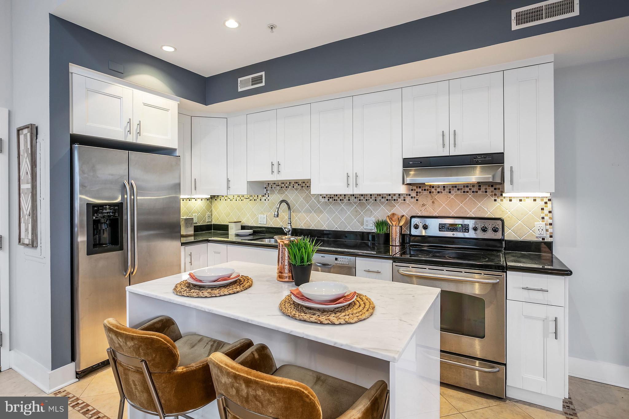 1461 Harvard Street Northwest, Unit 5 Washington, DC 20009 - Photo 10 of 33 a kitchen with stainless steel appliances granite countertop a stove a sink a refrigerator and white cabinets